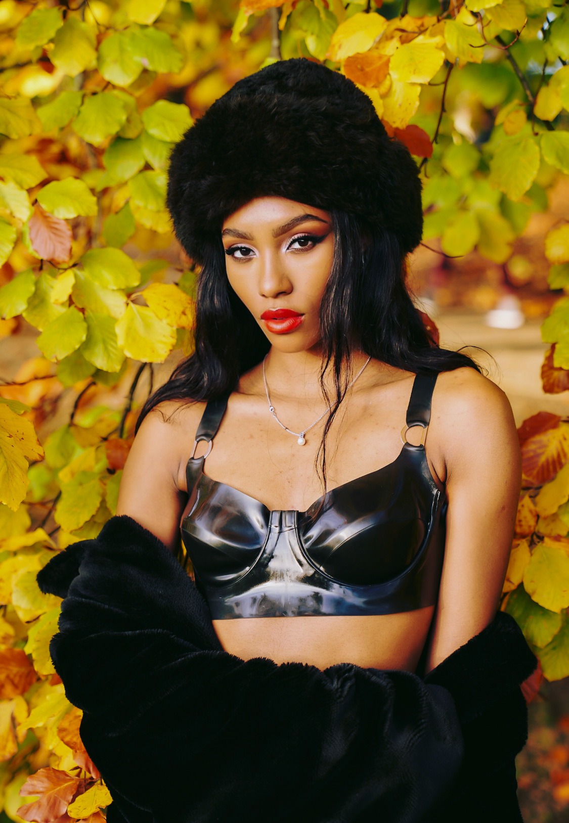 Isla Latham in a black faux fur hat and black leather top